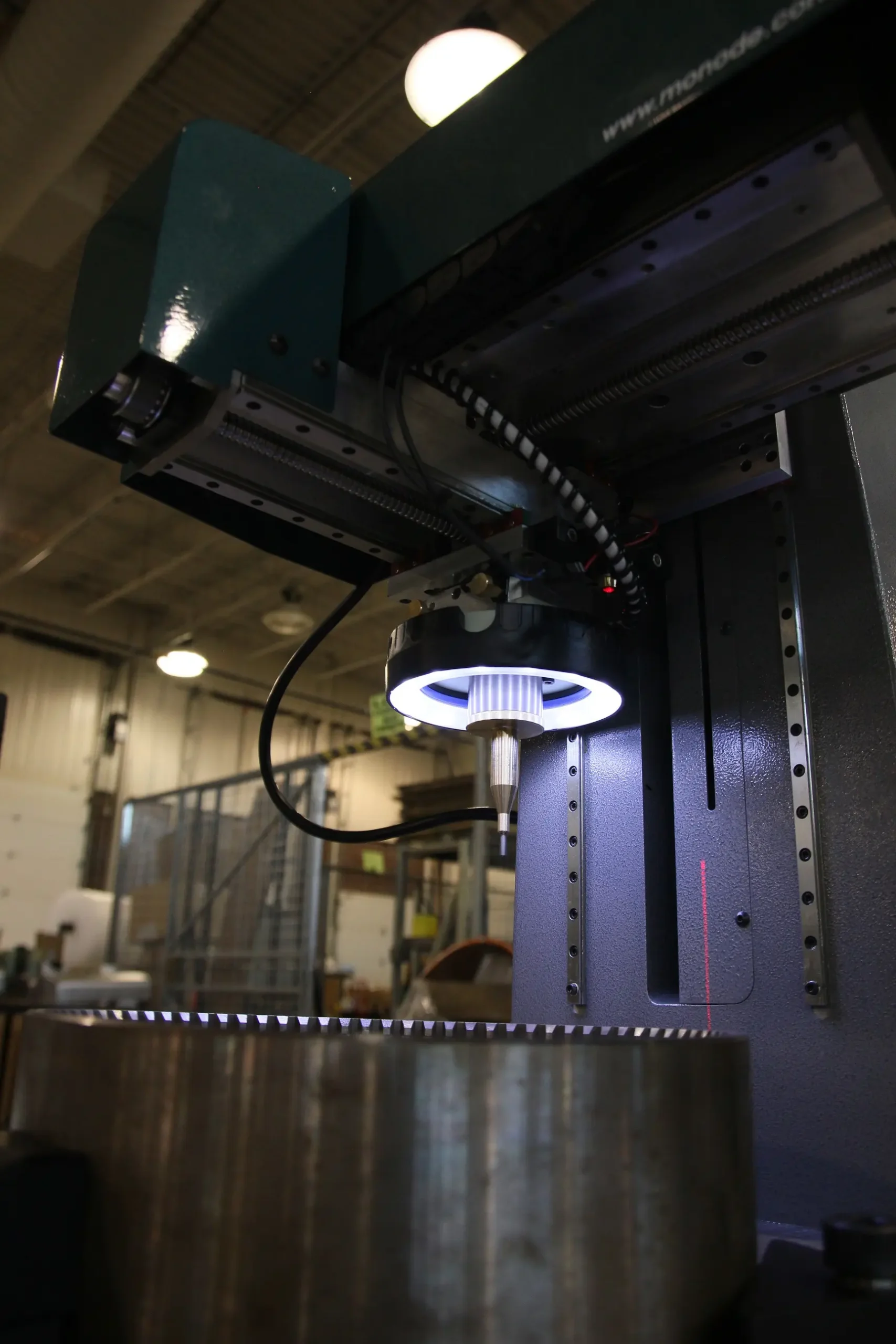 Industrial dot peen marking machine in operation with a bright ring light over the marking head