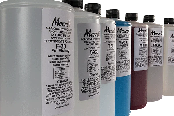 A row of Monode marking fluid bottles with labels showing different electrolyte formulas for etching