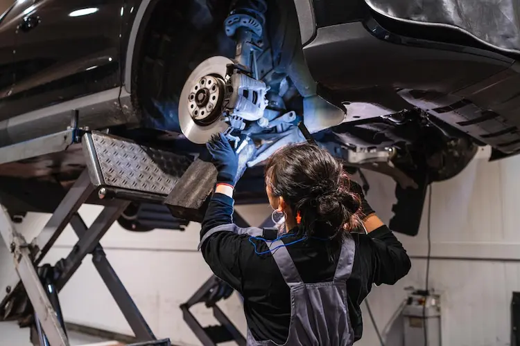 woman working on car